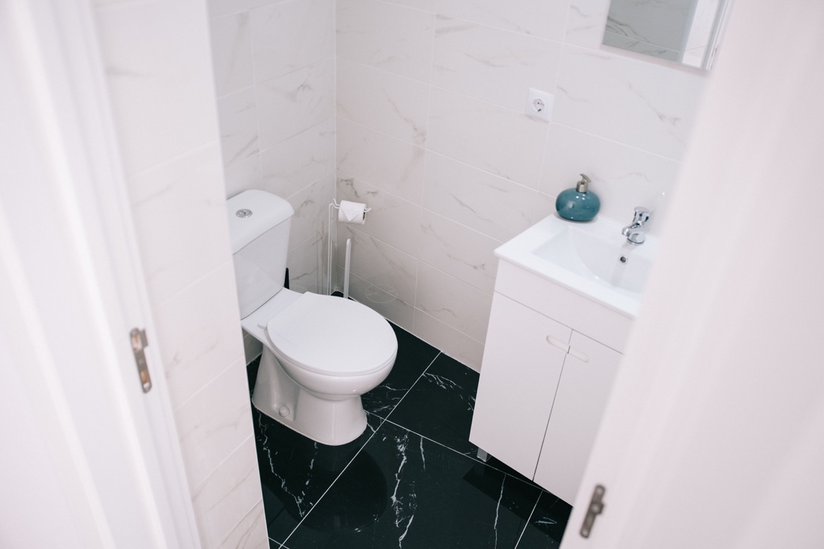Clean bathroom with toilet and vanity after fixture installation